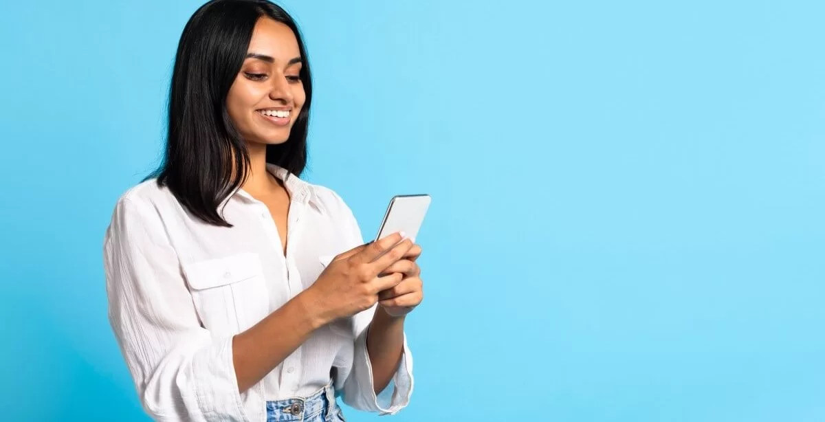 A imagem mostra uma mulher com traços indianos mexendo em um smartphone. Ela foi possivelmente impactada pelo conteúdo de alguma empresa que trabalhou o marketing no Instagram, tendo em vista que aparentemente está interagindo com alguma publicação.