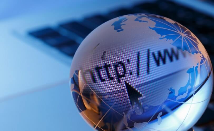 Uma ilustração com fundo azul e branco apresenta um globo terrestre e, sobre ele, um campo de digitação de URL, com um exemplo de endereço digitado. 