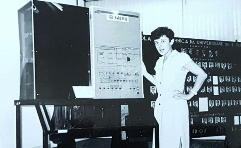 a imagem mostra Edith Ranzini ao lado do computador criado por uma equipe liderado por ela e que foi considerado o primeiro computador do Brasil.