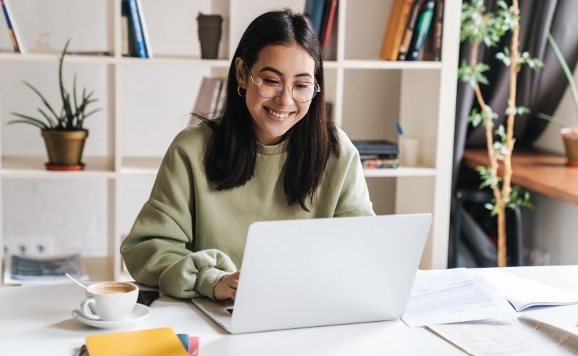 a imagem mostra uma moça em um escritório home-office trabalhando em frente a um notebook. A imagem faz referência ao Google Colab.