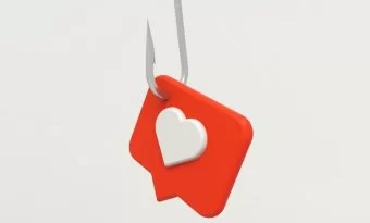 Na imagem há um quadro de fala vermelho, dentro há um coração branco e ele está pendurado em uma isca de pesca. A imagem faz referência ao conteúdo sobre clickbait também conhecido como isca virtual.