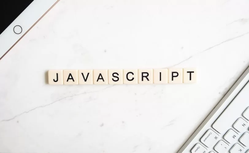 Na imagem há o nome 'javascript'. e nos cantos da imagem há um teclado de computador e no outro um ipad.
