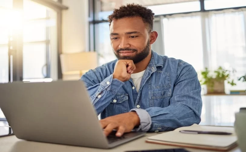 homem olhando para a tela de um notebook. 