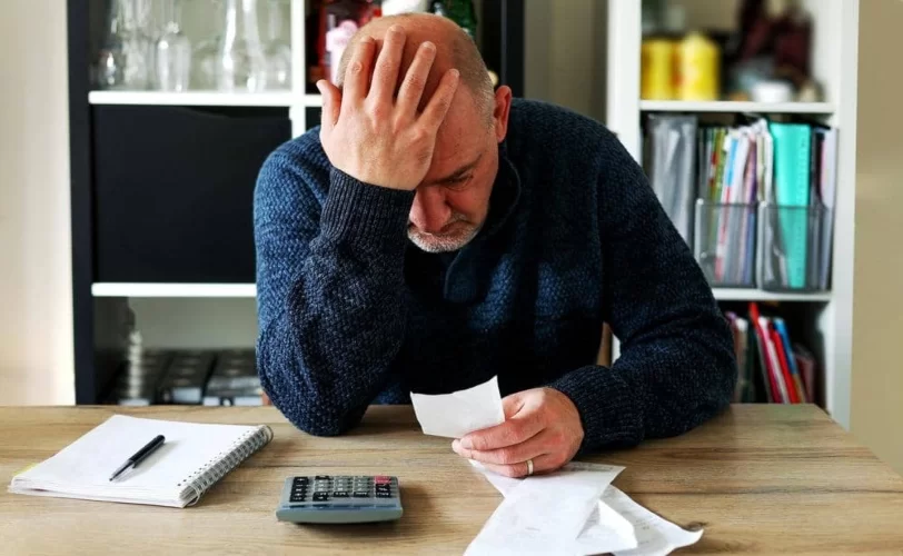 homem indignado olhando para um papel. 