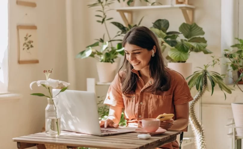 mulher trabalhando feliz em frente a um notebook.