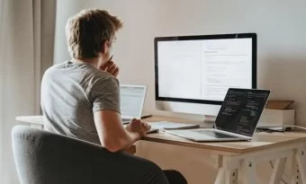 homem sentado frente a computador.