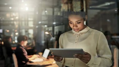 mulher em um escritório olhando um tablet