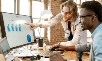 Dois empreendedores analisando dados na tela de um computador