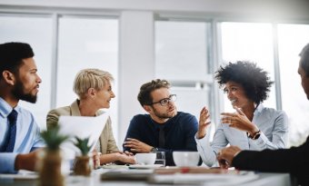 Pessoas conversando em uma sala de reuniões em uma empresa.