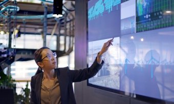 Mulher mostrando dados em uma tela.