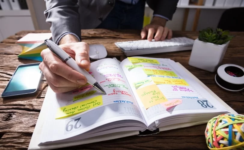 pessoa utilizando caderno para organizar tarefas e processos do trabalho remoto