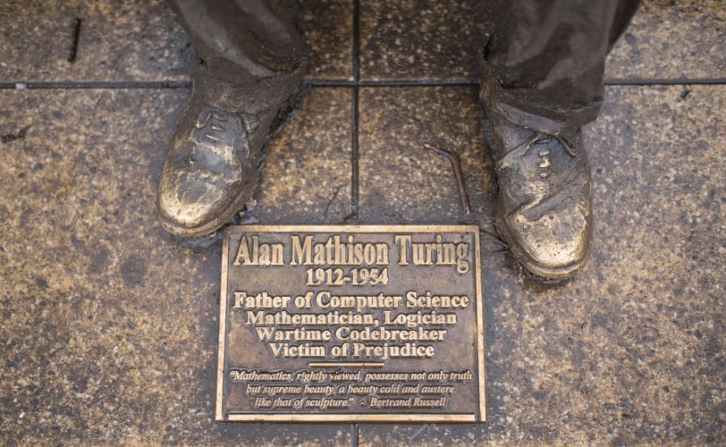 imagem mostra placa descritiva da escultura de Alan Turing na Inglatera