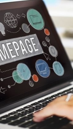 notebook aberto com a palavra homepage escrita em fonte grande no centro da tela