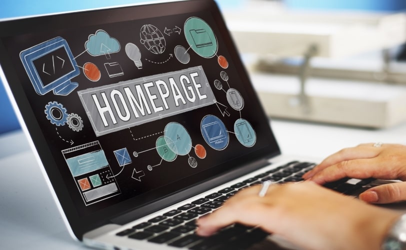 notebook aberto com a palavra homepage escrita em fonte grande no centro da tela