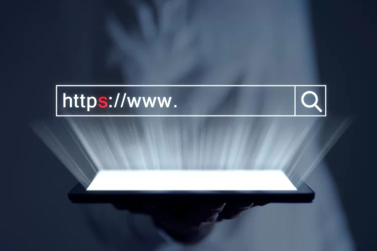 magem ilustrativa sobre como otimizar um site para mecanismos de busca. Uma mão está segurando um tablet iluminado. Acima da luz tem uma caixa de pesquisa com www.