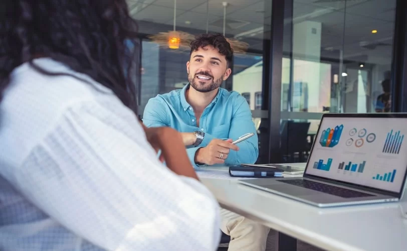 duas pessoas planejando campanhas de marketing em uma sala de reuniões