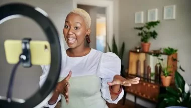 mulher gravando vídeo para redes sociais, já que este é um dos tipos de conteúdo mais consumidos atualmente
