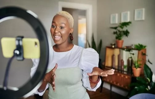 mulher gravando vídeo para redes sociais, já que este é um dos tipos de conteúdo mais consumidos atualmente