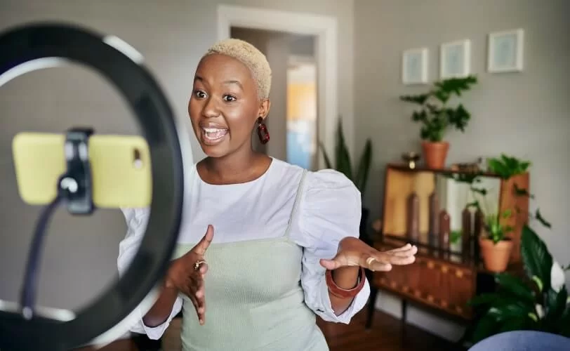 mulher gravando vídeo para redes sociais, já que este é um dos tipos de conteúdo mais consumidos atualmente