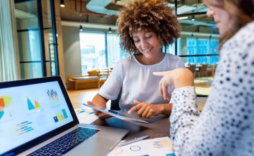  Duas mulheres estão conversando em um escritório sobre cultura data driven.  