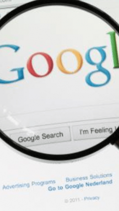 A imagem mostra uma lupa sobre o logo do Google na página de busca da empresa.