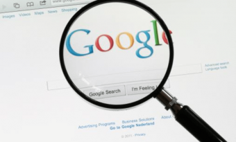 A imagem mostra uma lupa sobre o logo do Google na página de busca da empresa.