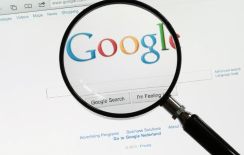 A imagem mostra uma lupa sobre o logo do Google na página de busca da empresa.