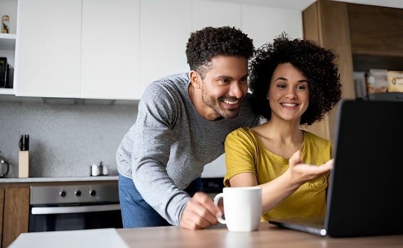 Homem e mulher olhando produtos para comprar em um computador.  