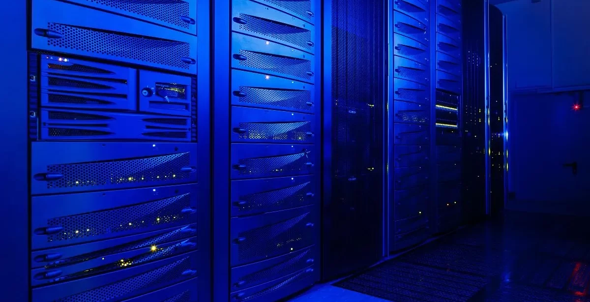 A imagem mostra uma sala de servidores, onde todos eles estão ligados para manter o bom funcionamento dos serviços e sites de uma empresa.
