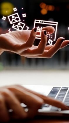 A imagem mostra uma mulher sentada em frente a um notebook e acima da suas mãos há hologramas de ícones da internet.