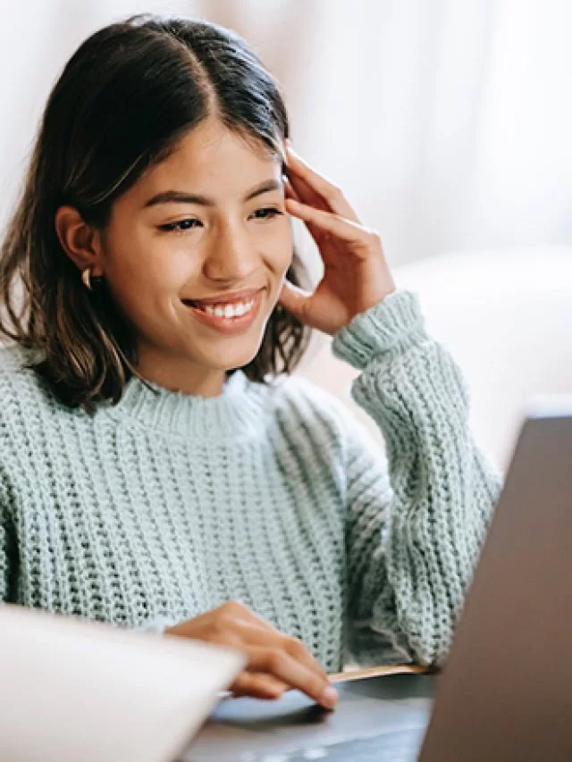 Mulher sorrindo diante de um computador