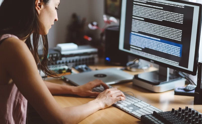 Mulher digitando em computador de mesa