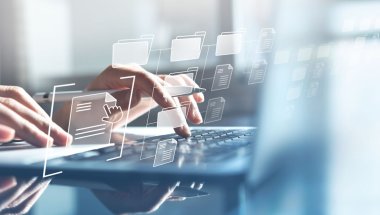 Mãos digitando em laptop. Há uma estrutura de pastas e arquivos sobre elas