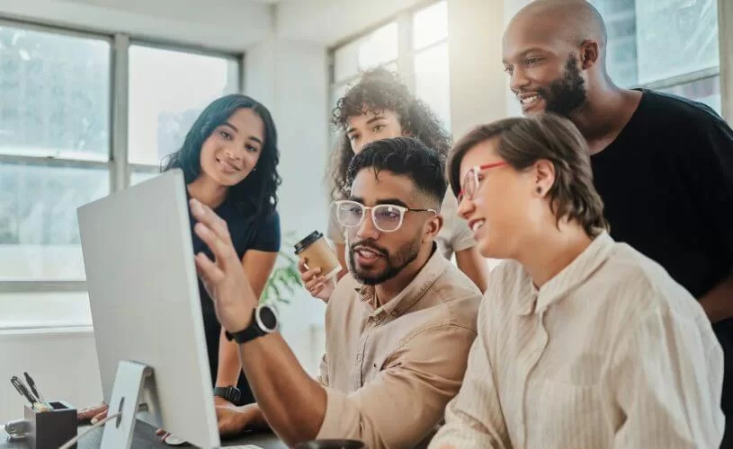 Equipe de trabalho ao redor de um desktop