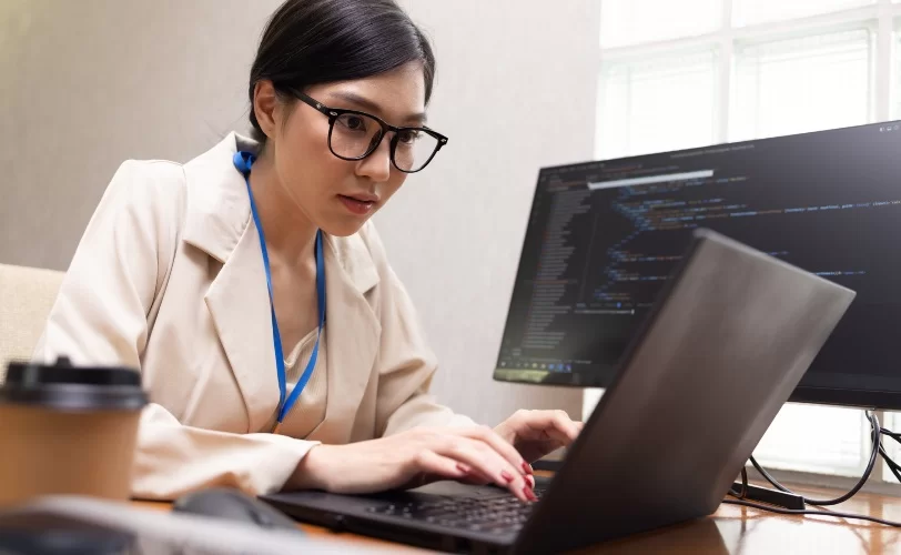 Programadora digitando em laptop