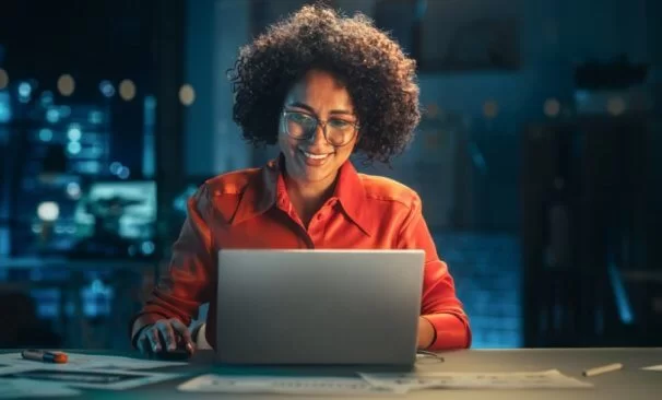 mulher usando computador e sorrindo