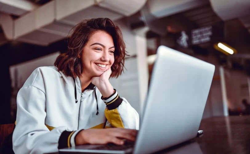 mulher usando computador enquanto sorri