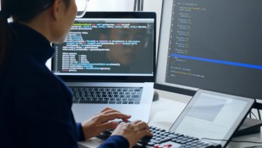 Desenvolvedora usando óculos trabalhando em computador