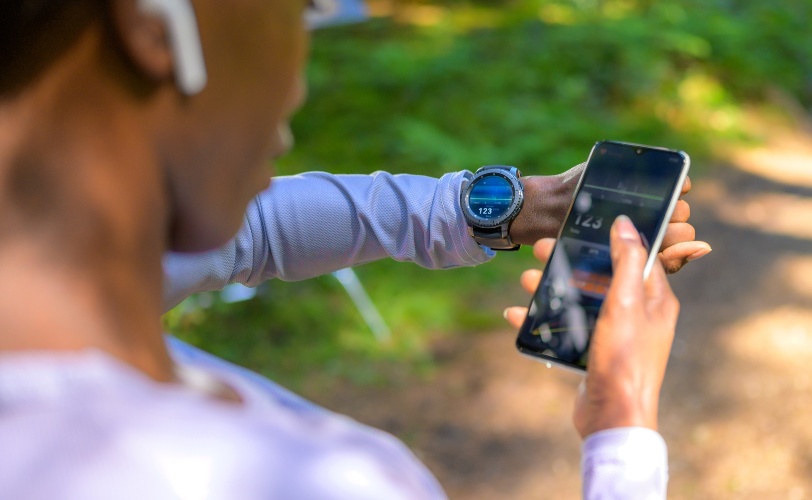 Mulher sincronizando dados de exercícios físicos entre smartwatch e smartphone