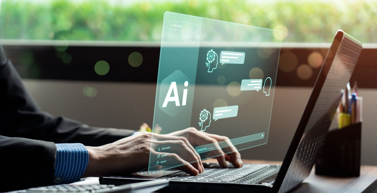 Uma pessoa está digitando em um laptop, com uma sobreposição digital exibindo elementos de IA (Inteligência Artificial), incluindo bolhas de bate-papo e ícones. O fundo mostra uma cena externa borrada e cheia de vegetação vista através de uma janela.