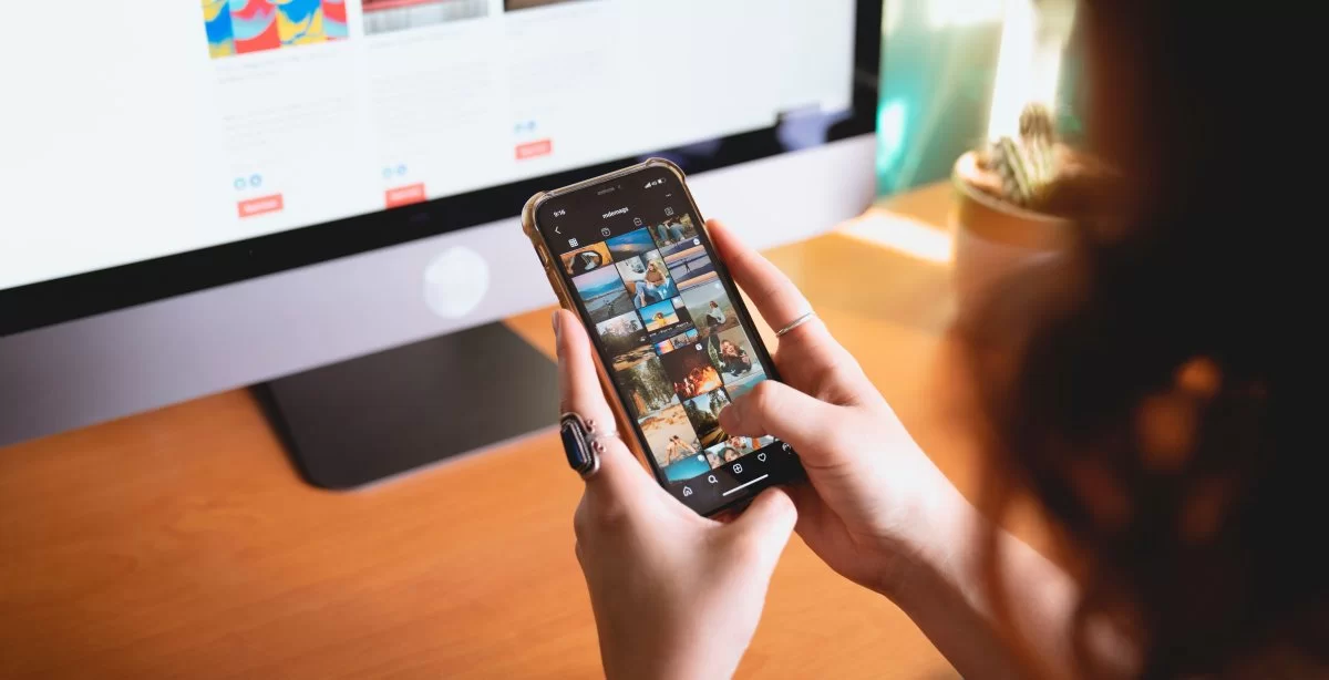Tela de smartphone mostrando o feed do Instagram sendo rolado, ilustrando o momento de consumo de conteúdo na rede social