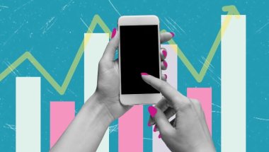 Um par de mãos femininas desliza um dos dedos indicadores sobre a tela do celular. Ao fundo, é possível visualizar barras brancas e rosas, que compõe um gráfico disposto sob as mãos, representando a ideia em torno das principais tendências de marketing para 2025.