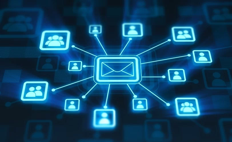 A imagem apresenta uma representação digital de um sistema de e-mails em uma rede global. No centro, há um ícone de envelope conectado a diversos outros ícones de usuários, simbolizando a comunicação entre várias pessoas ou dispositivos, como proposto pelo protocolo IMAP. O fundo escuro com tons de azul e linhas brilhantes sugere tecnologia, conectividade e transmissão de dados em tempo real.