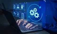 A imagem mostra uma cena conceitual de automação e tecnologia digital. Um profissional está digitando em um notebook, enquanto sobre a tela aparecem ícones digitais em azul, representando diferentes processos: engrenagens, checklist, segurança, inteligência artificial e validações. O destaque principal é o ícone de engrenagens em movimento, cercado por setas circulares, simbolizando o fluxo contínuo de automação de tarefas.