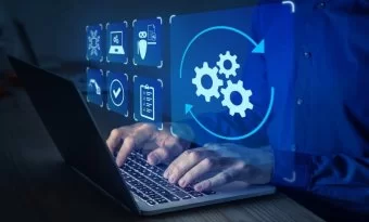 A imagem mostra uma cena conceitual de automação e tecnologia digital. Um profissional está digitando em um notebook, enquanto sobre a tela aparecem ícones digitais em azul, representando diferentes processos: engrenagens, checklist, segurança, inteligência artificial e validações. O destaque principal é o ícone de engrenagens em movimento, cercado por setas circulares, simbolizando o fluxo contínuo de automação de tarefas.