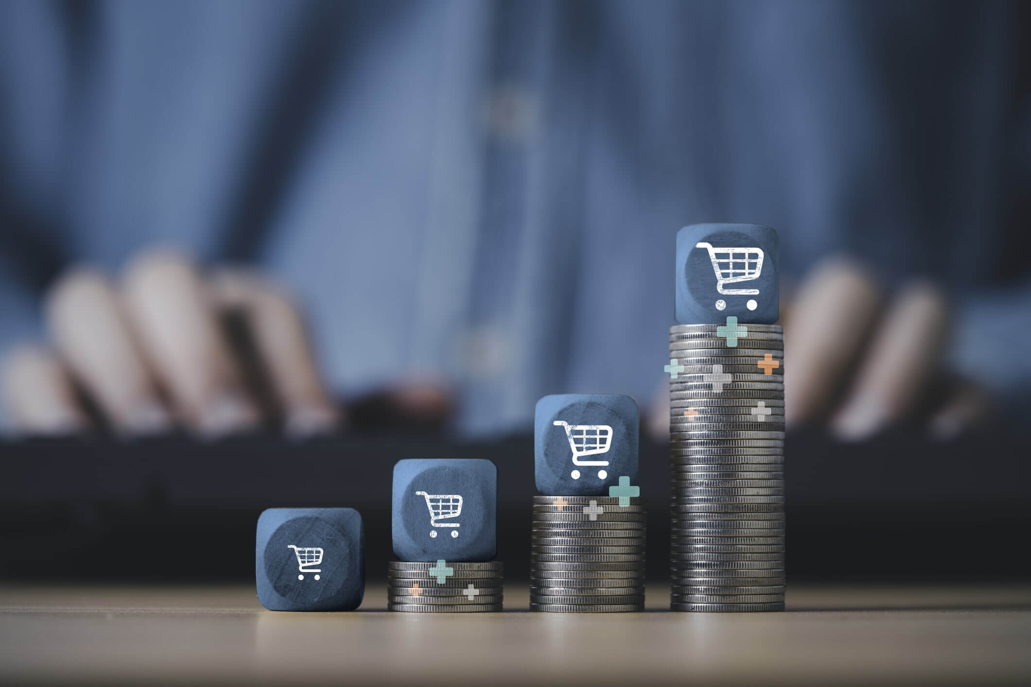 Carrinho de compras empilhado no topo do empilhamento de moedas crescentes para o conceito de crescimento de negócios de venda online.