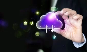 A imagem apresenta um ícone de nuvem digital com setas de upload e download, simbolizando o armazenamento e compartilhamento de informações em sistemas de computação em nuvem. As linhas luminosas e o fundo azul com partículas tecnológicas reforçam a ideia de fluxo de dados, conectividade e infraestrutura digital. Essa representação ilustra como a nuvem (cloud computing) permite o acesso remoto, a integração entre dispositivos e a agilidade nos processos corporativos, sendo um pilar essencial da transformação digital e da inovação tecnológica.