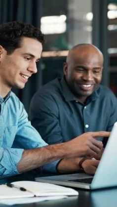 A imagem mostra dois homens conversando em um escritório, enquanto olham para um notebook e discutem sobre criar site com IA.